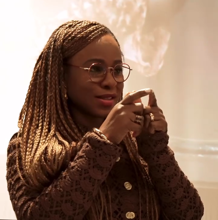 FRK Screening Kings College - Bolanle Austen‑Peters at the Bush House podium, left index finger and thumb touching near her face, delivering the line about national wealth being in people’s talent.